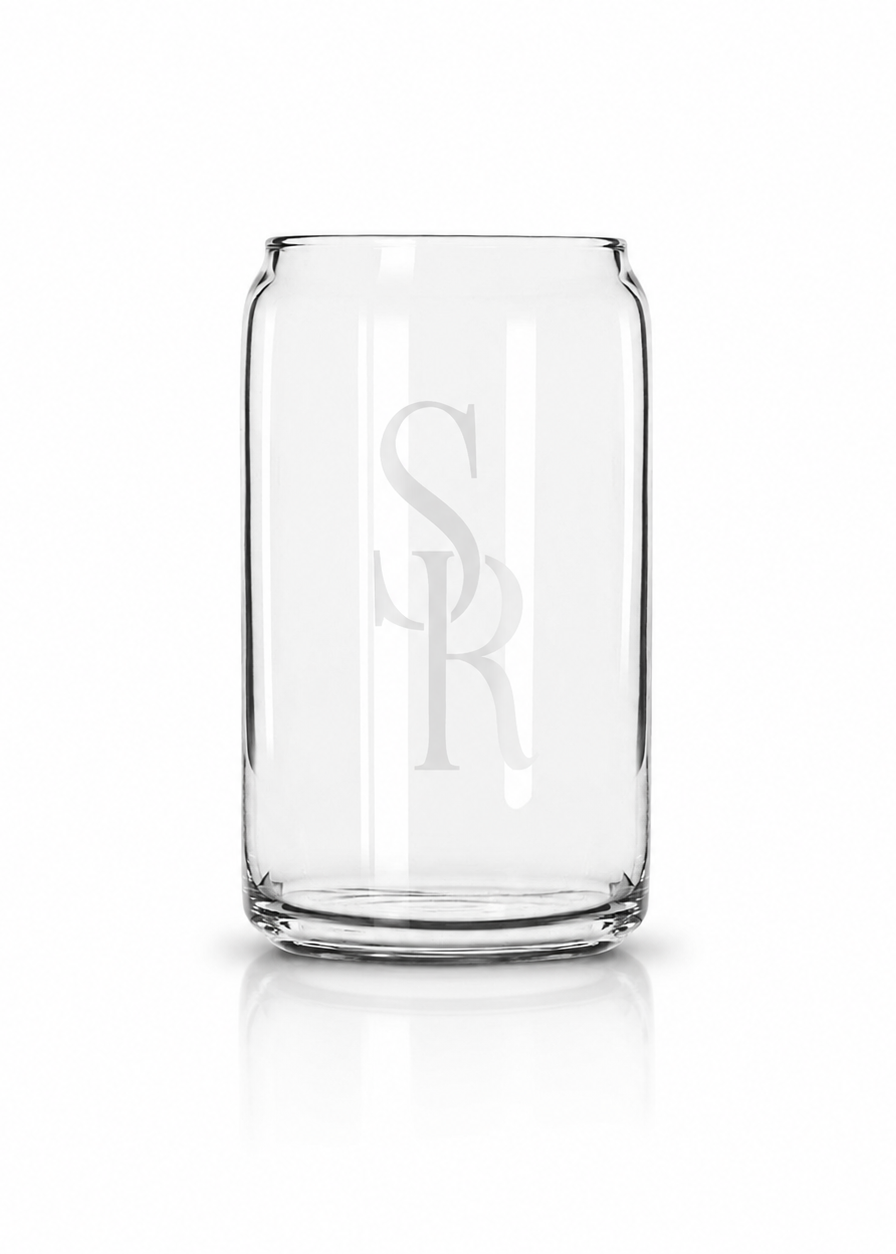 A clear rectangular drinking glass with a monogrammed 'SR' design on the front, shown on a clean white background with a soft reflection underneath.