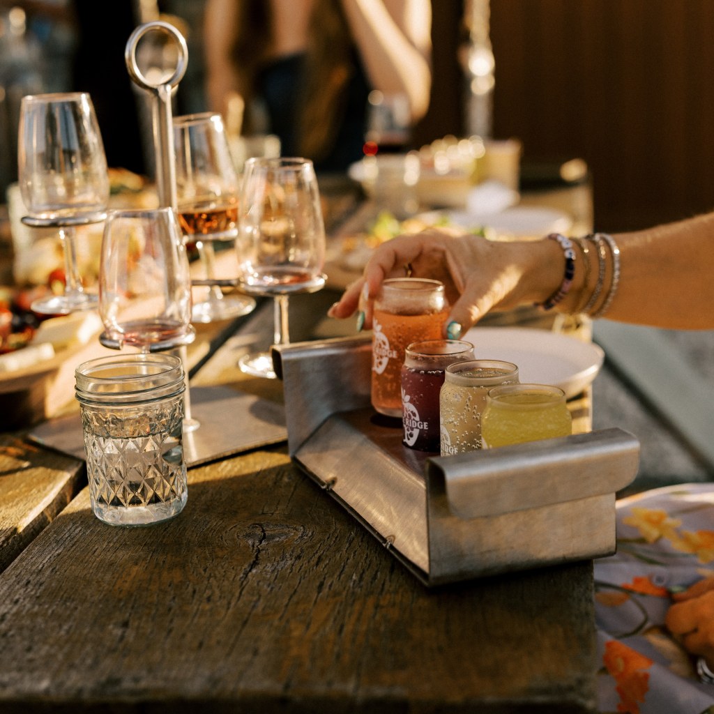 Wine and cider tasting flight on a wooden table at Shale Ridge Nordic Spa in Ontario wine country