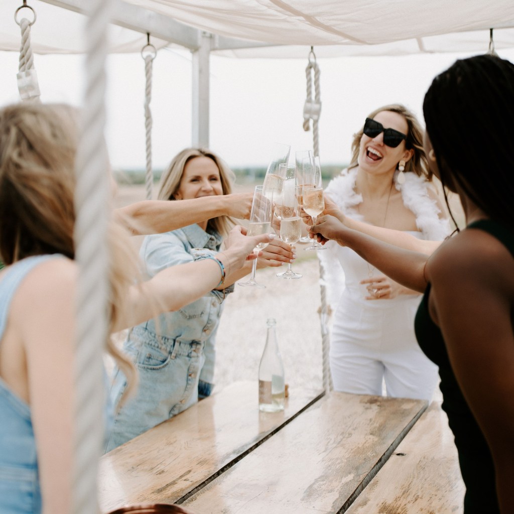Friends toasting champagne glasses at Shale Ridge outdoor experience space